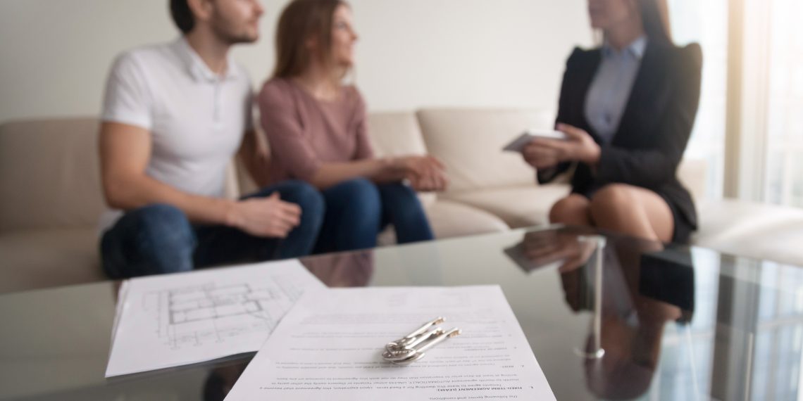 Young,Renters,Couple,Sitting,On,Couch,Discussing,Renting,Apartment,With