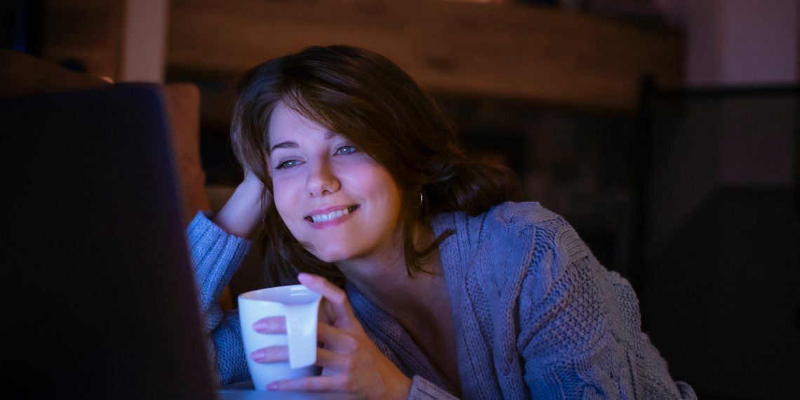 Pretty,Smiling,Woman,Watching,A,Movie,On,Her,Laptop,At